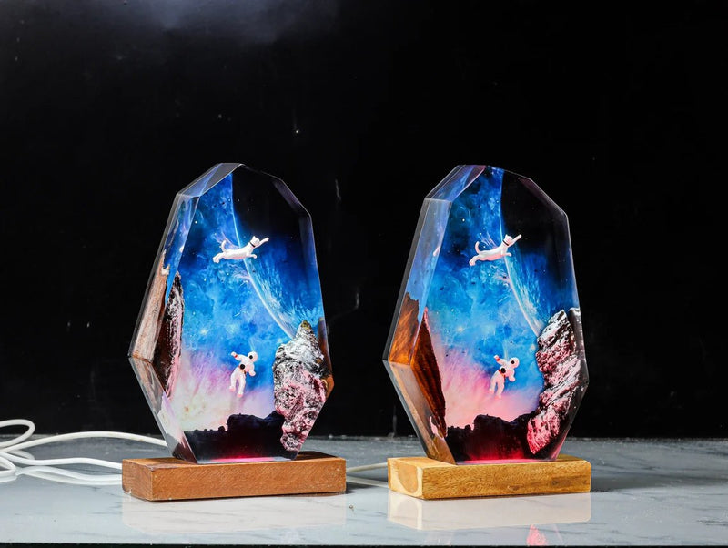 Two astronaut and cat resin lamps side by side