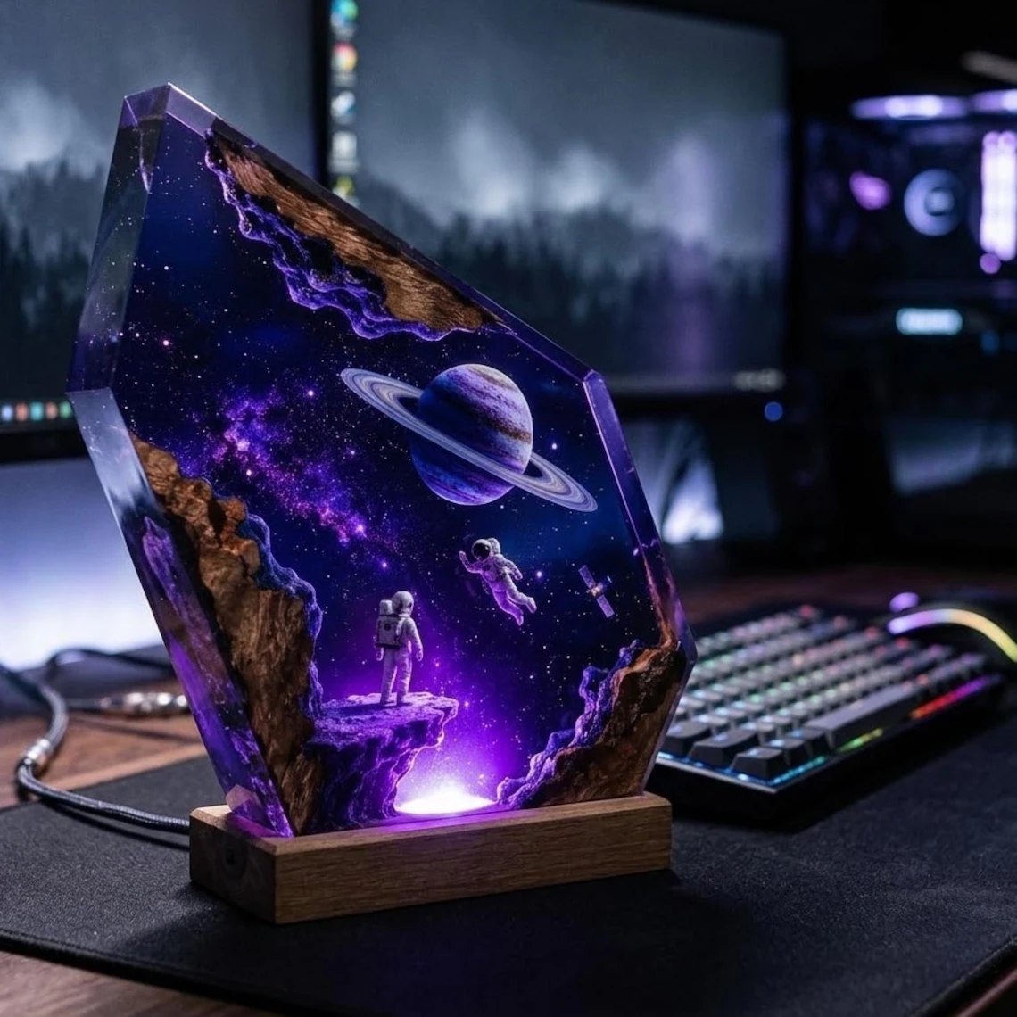 Astronaut ringed planet resin lamp glowing purple beside a keyboard