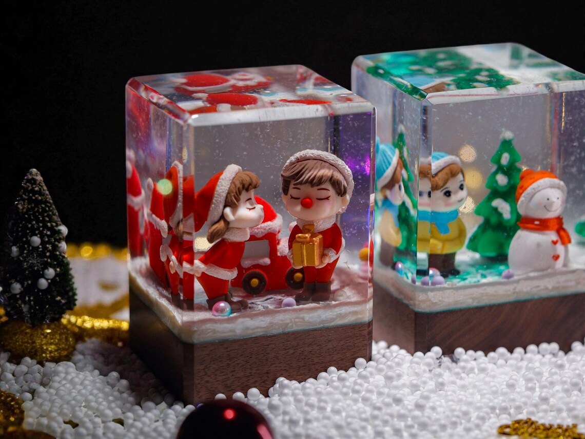 Christmas couple resin cube beside another Christmas resin cube