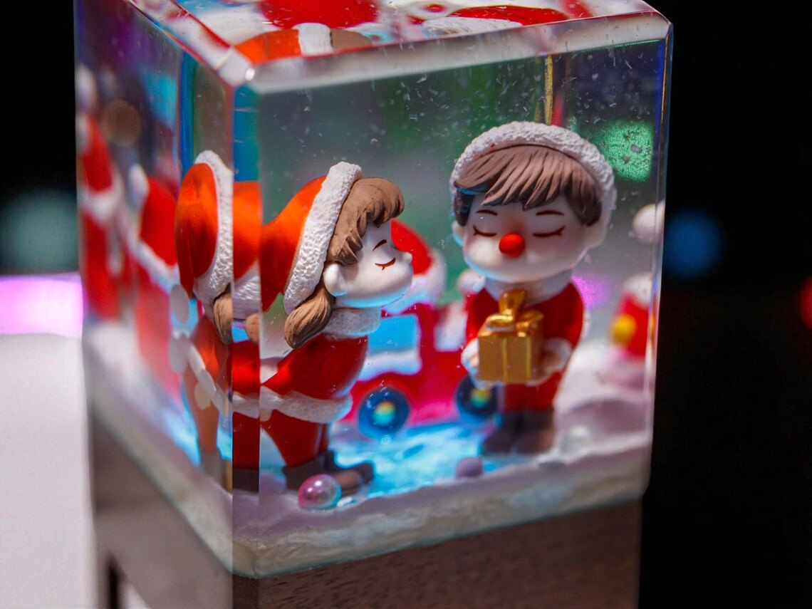 Close-up of couple in Santa outfits holding a gift