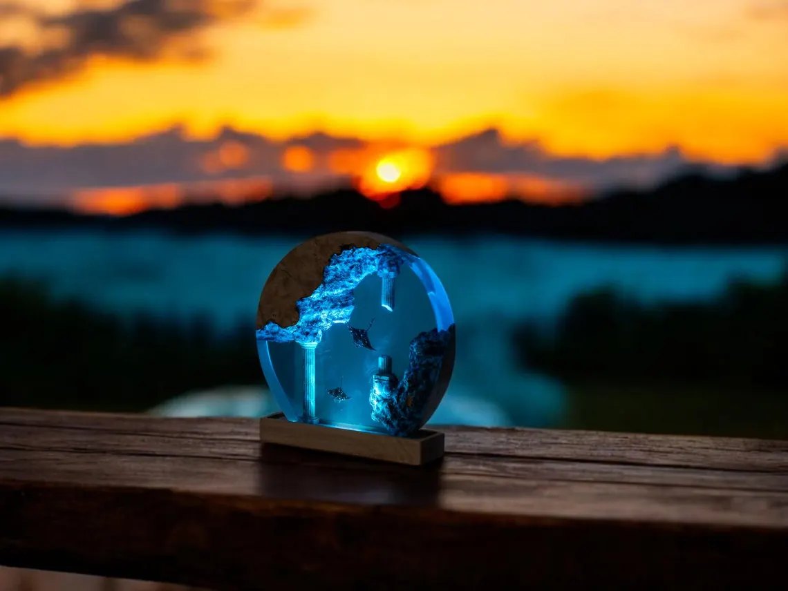 Round ocean resin lamp on a wooden ledge at sunset