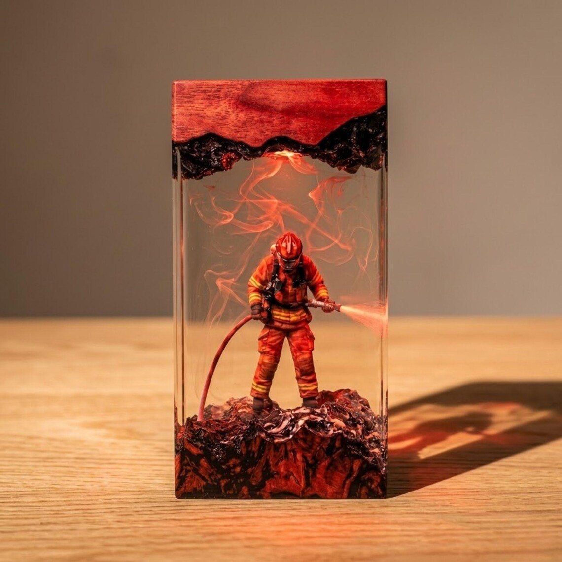 Firefighter resin lamp in red light on a wooden table