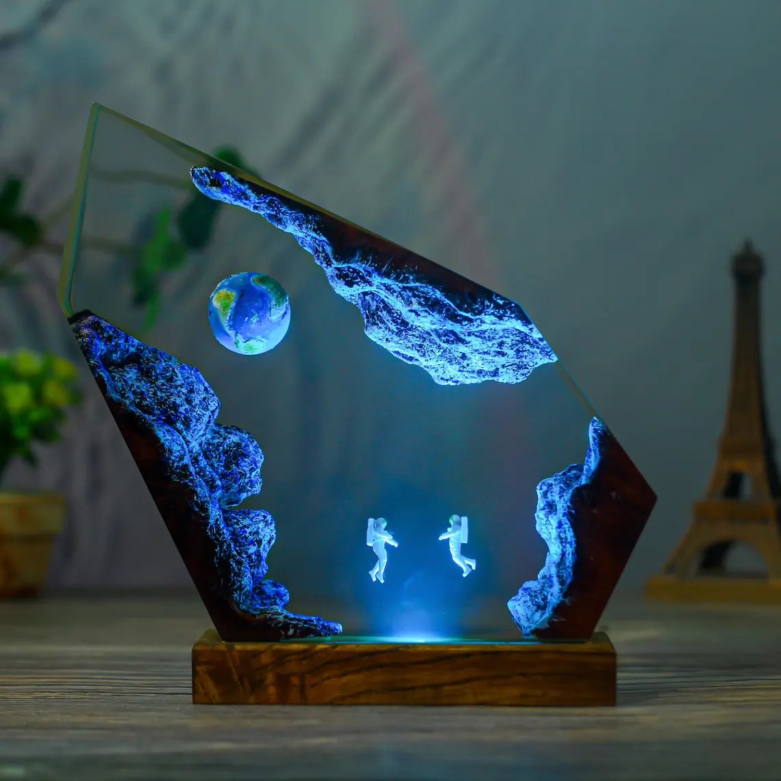 Astronaut resin lamp with Earth in blue light on a desk