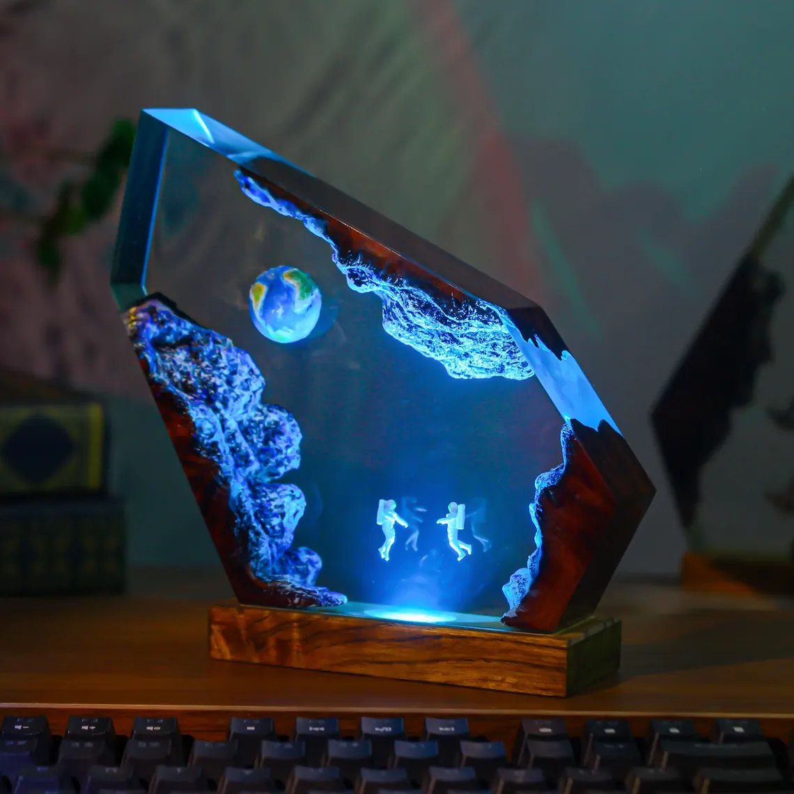 Floating astronauts epoxy lamp in cool blue light