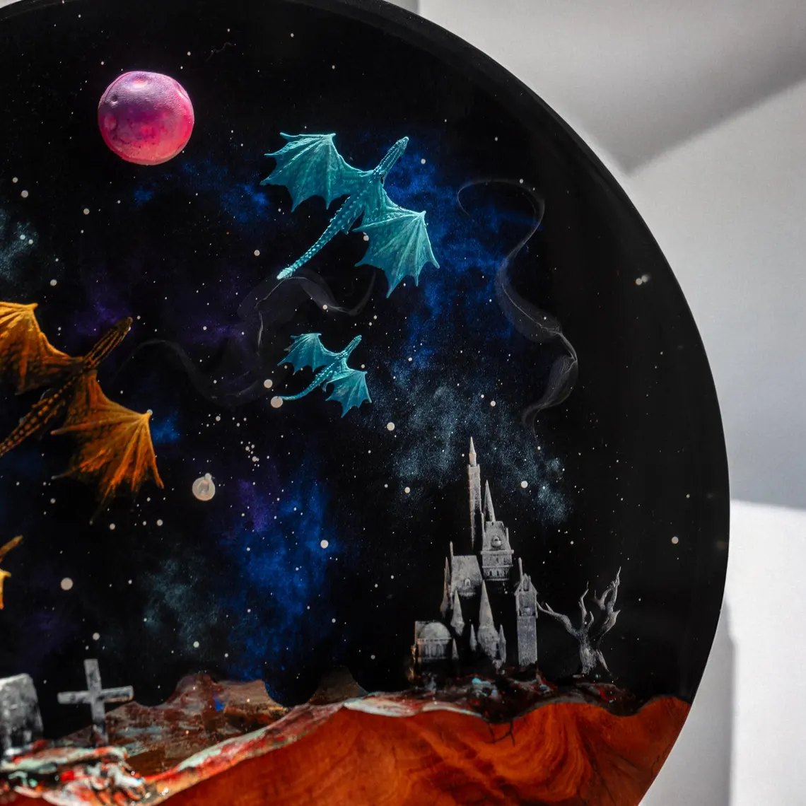 Close-up of teal dragons, pink moon and castle in the resin