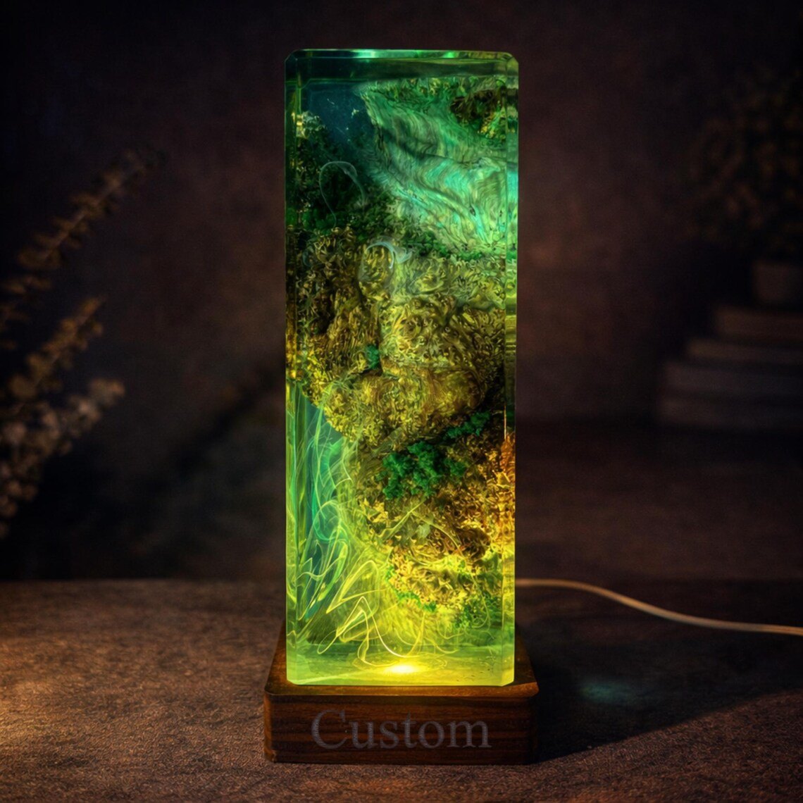 Moss resin lamp tower glowing yellow-green on a wood base
