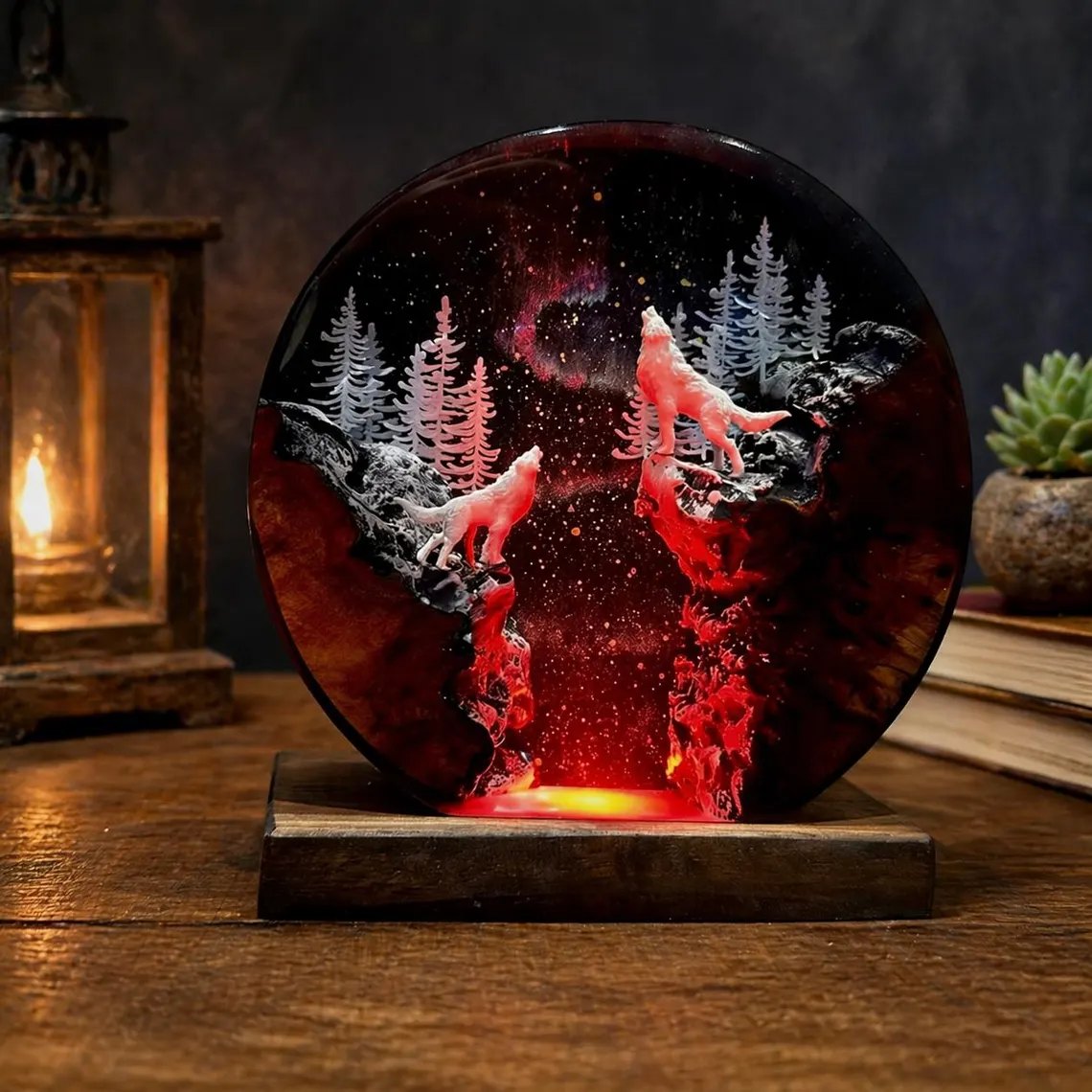 Two howling wolves resin lamp lit in red beside a lantern
