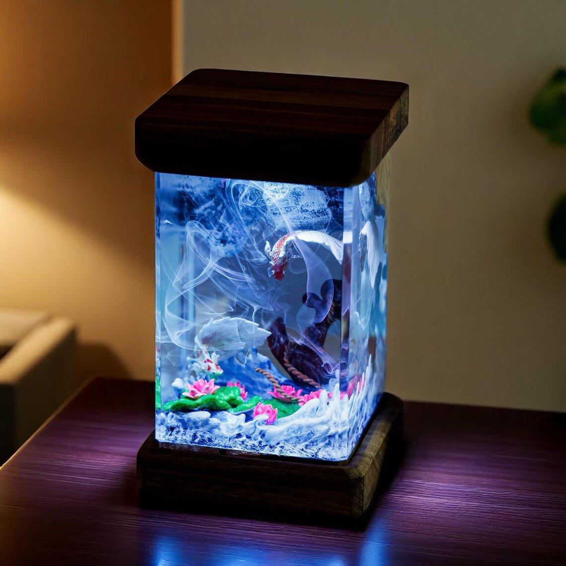 Koi resin lamp glowing blue on a dark wood table