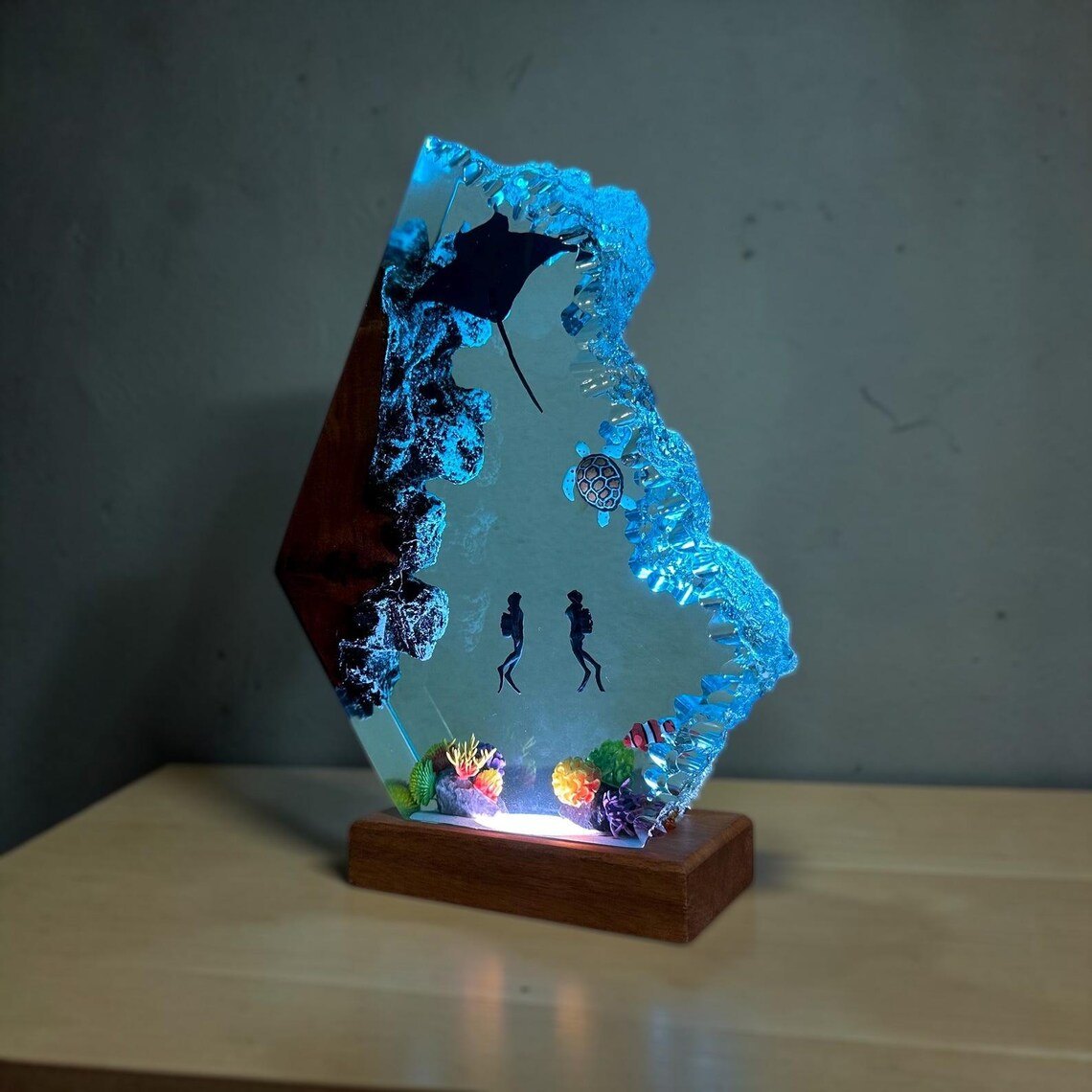 Angled view of the manta ray resin lamp on a wood base