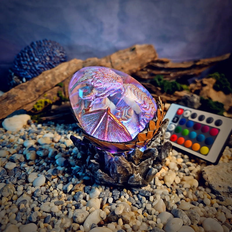 Dragon egg resin lamp with a pearl white dragon glowing pink-lilac