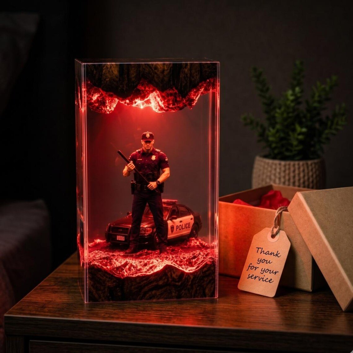 Police officer resin lamp glowing red beside a gift box