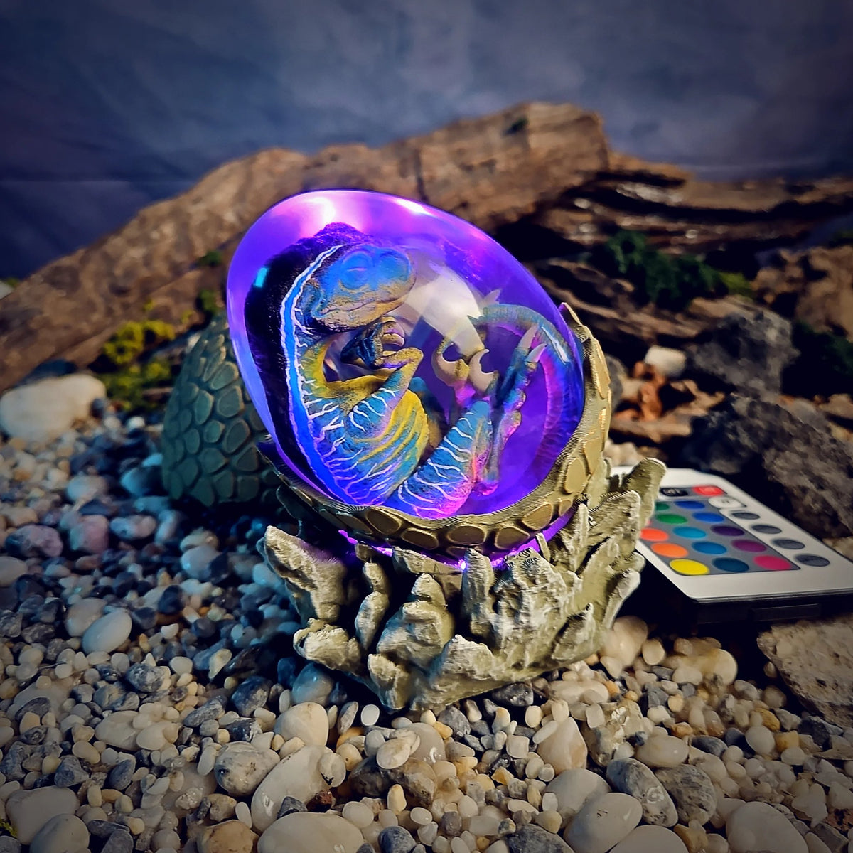 Raptor embryo egg lamp glowing violet beside its remote