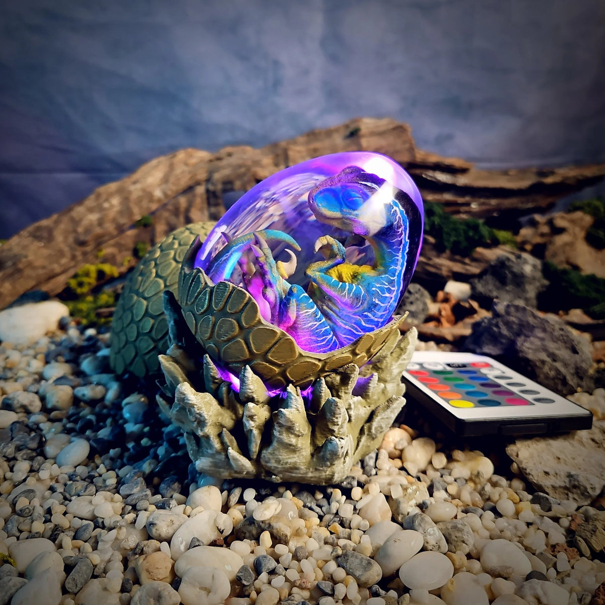 Dinosaur egg lamp glowing purple on its sculpted rock cradle