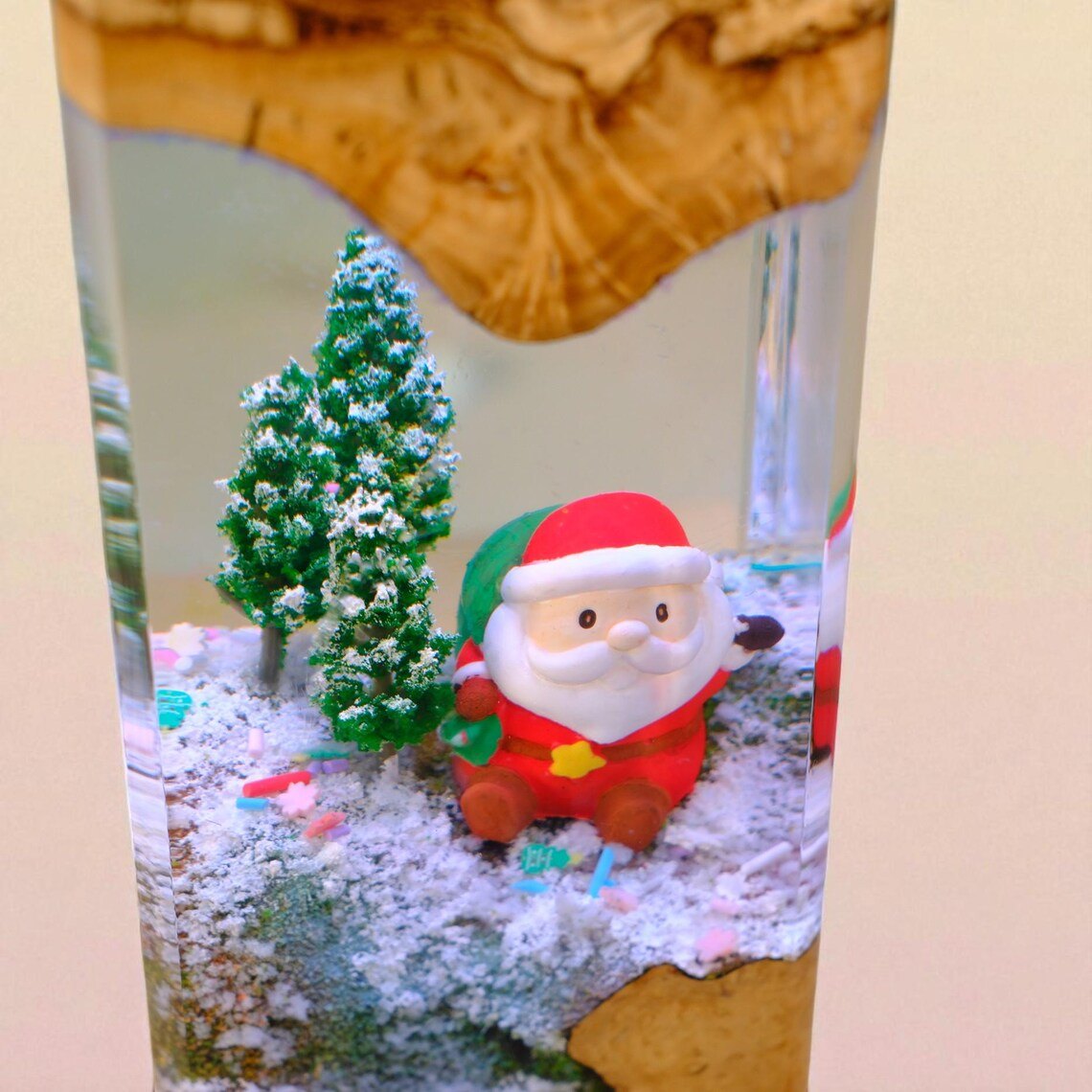 Close-up of Santa figure and frosted pine trees in resin