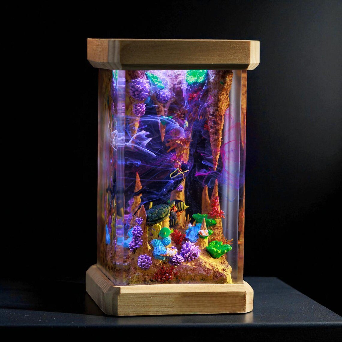 Sea cave resin lamp glowing violet on a dark shelf