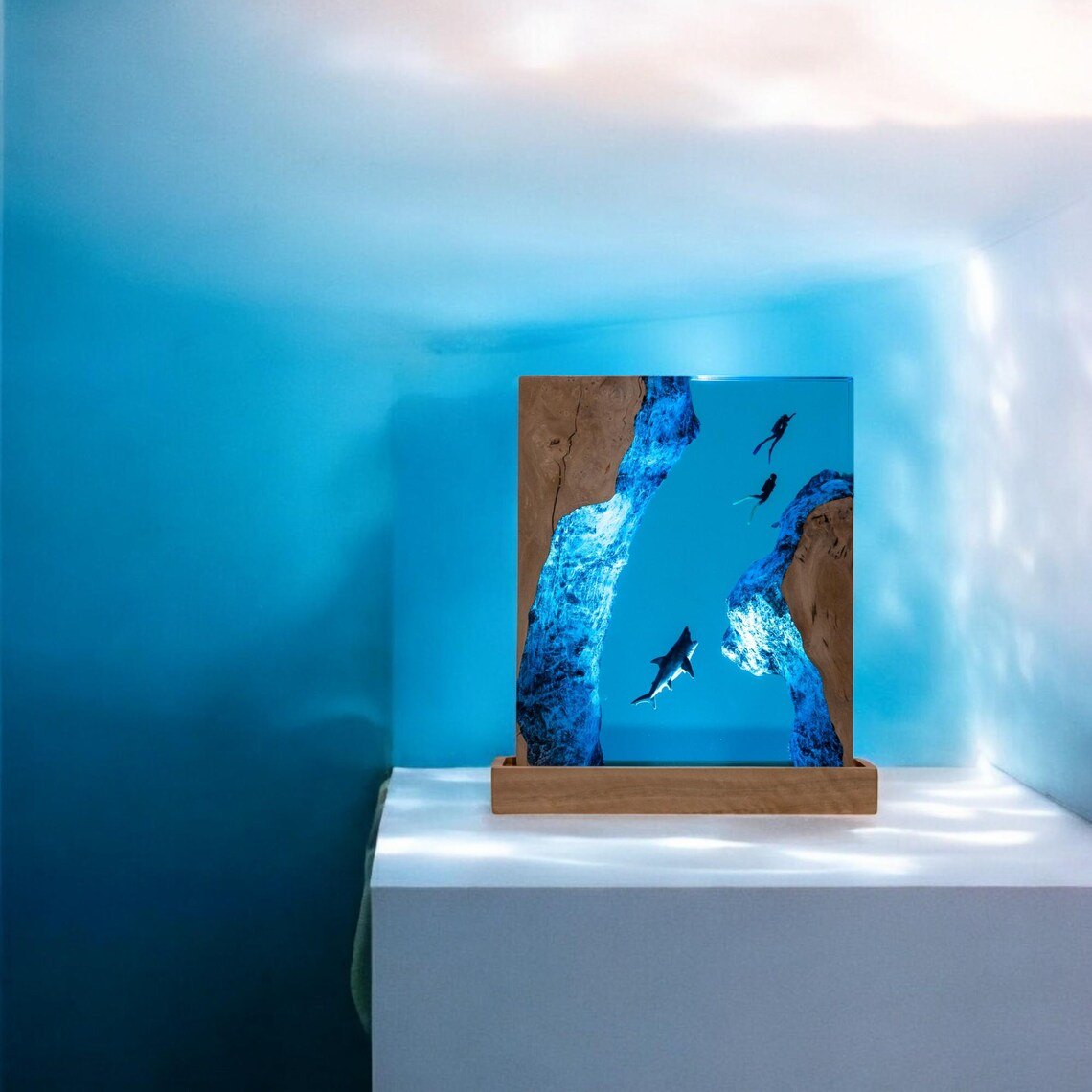 Shark resin lamp on a white pedestal in blue light