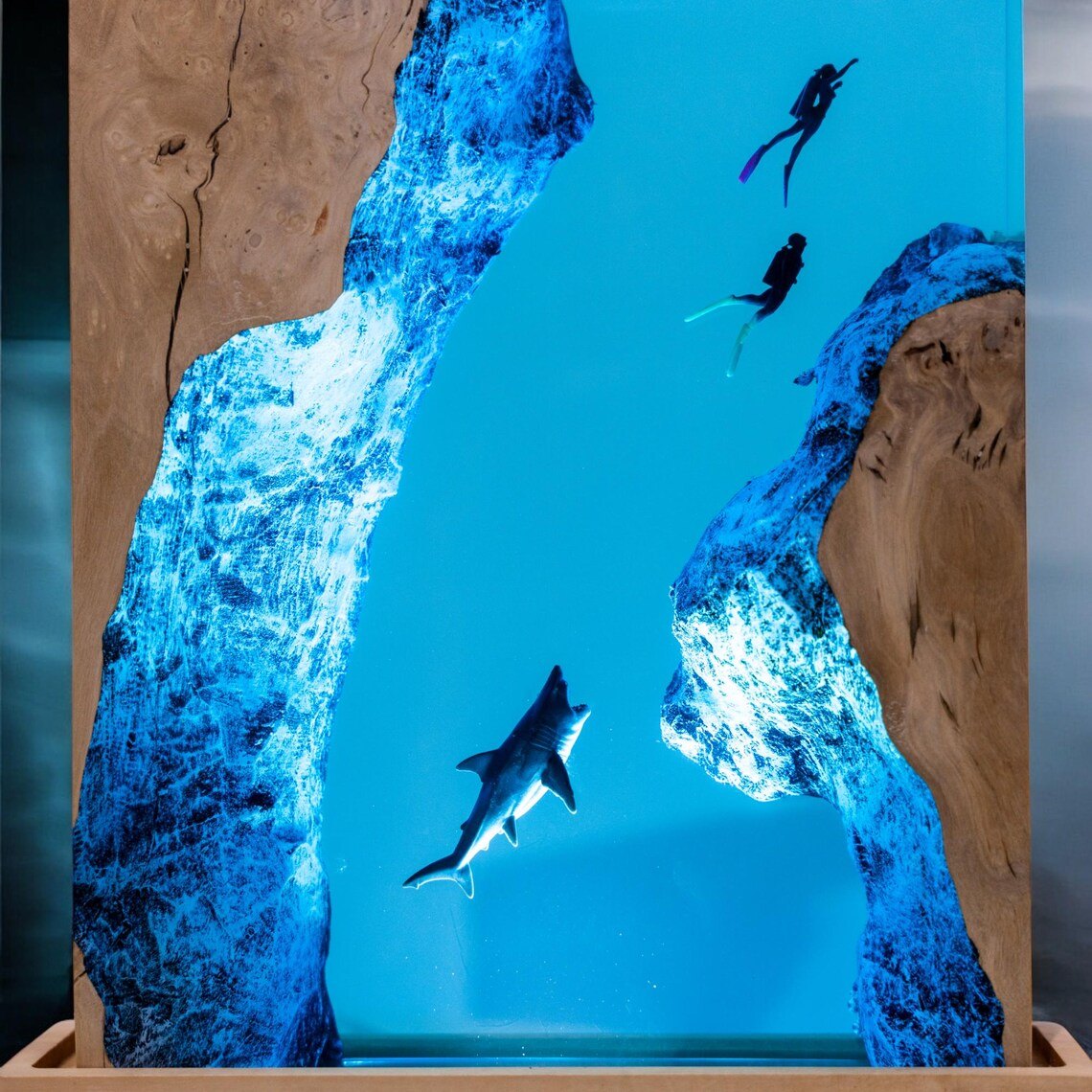 Close-up of shark and diver silhouettes in blue resin