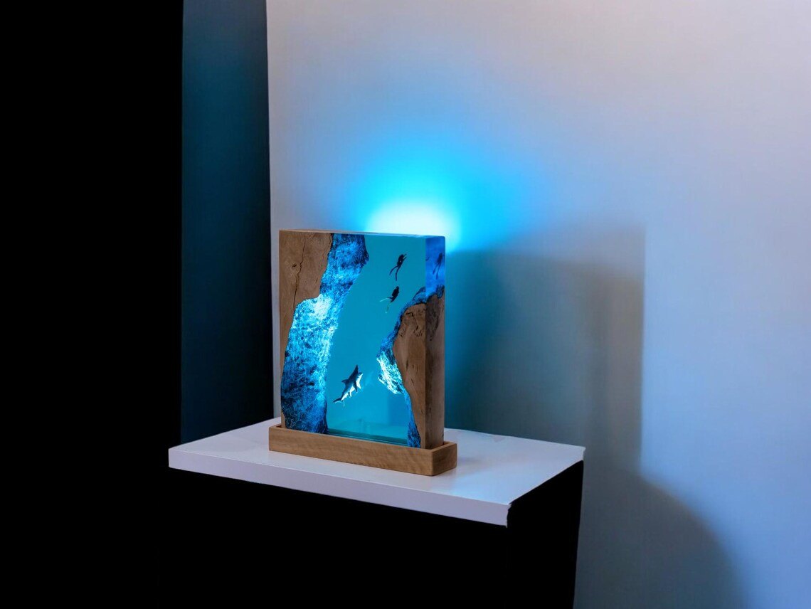Shark resin lamp glowing on a white shelf