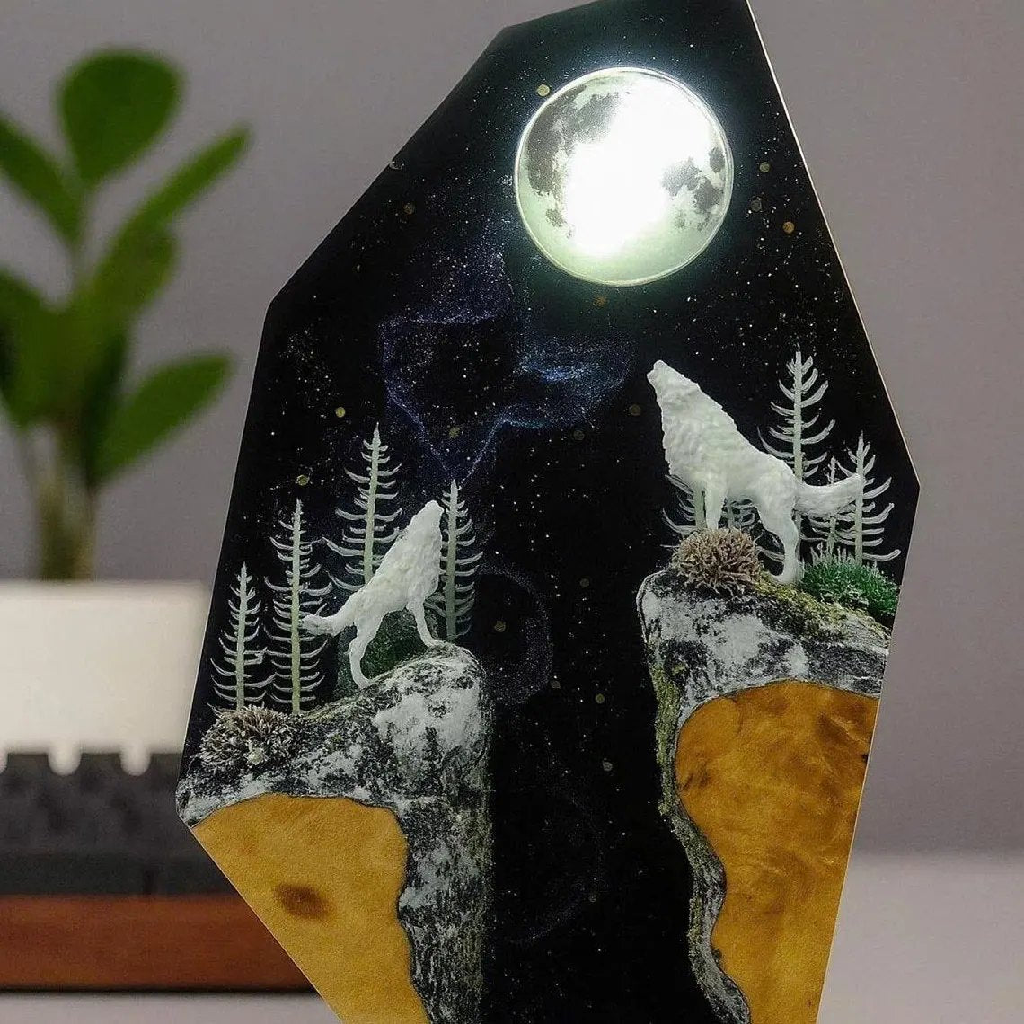 Close view of two white wolves and pines under the moon